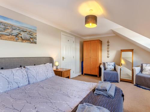 um quarto com uma cama grande e uma cadeira em 3 Bed in Appledore 00851 em Appledore