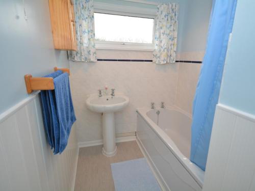 een badkamer met een wastafel, een bad en een wastafel bij 3 Bed in St Day 37014 in Saint Day