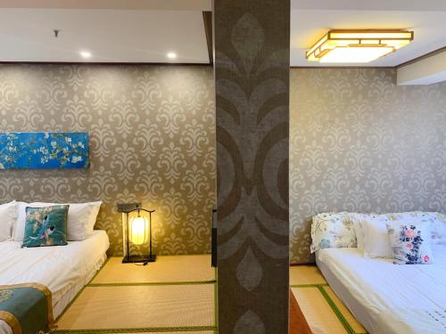 a room with two beds and a lamp in it at Suzhou Jade Snow Lodge in Suzhou