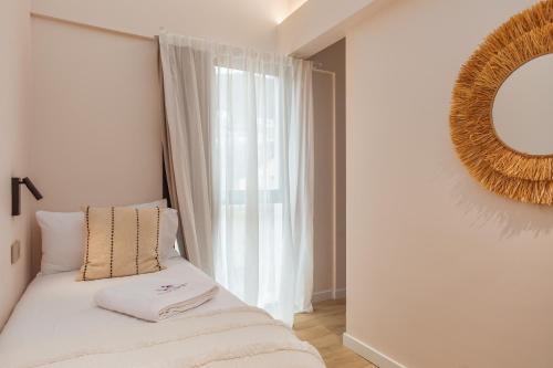 a bedroom with a bed with a mirror and a window at Marconia Boutique Residence in L'Estartit