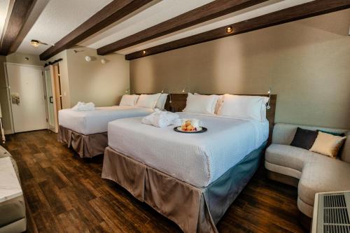 a hotel room with two beds and a couch at Old Orchard Inn in Wolfville
