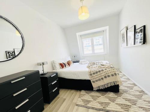 Schlafzimmer mit einem Bett, einer Kommode und einem Spiegel in der Unterkunft 2 Bed Apartment next to Finsbury Park Station! (C) in London