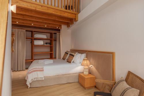 a bedroom with a bed and a chair in it at Marconia Boutique Residence in L'Estartit