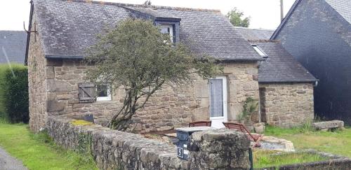 an old stone house with a stone wall at gite 2 ou 3 personnes - campagne in Bourbriac