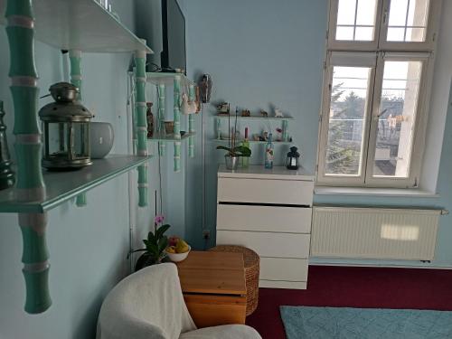 una cocina con paredes verdes y blancas y una ventana en - PASTELOWY loft -, en Sopot