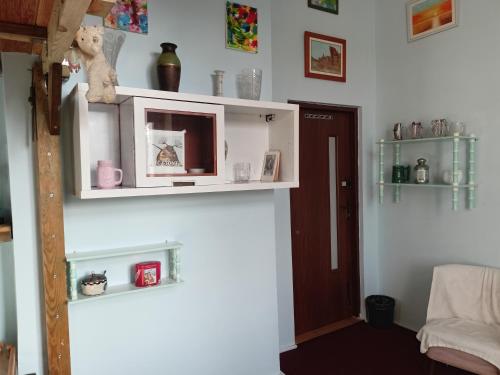 ein Zimmer mit einem weißen Regal mit einem Teddybär darauf in der Unterkunft - PASTELOWY loft - in Sopot
