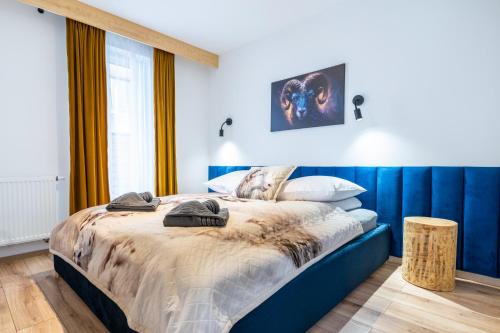 sypialnia z łóżkiem z niebieskim zagłówkiem w obiekcie Czarny Baran w Zakopanem