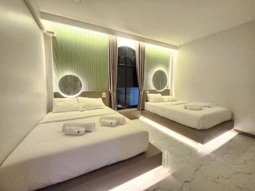 2 camas en una habitación de hotel con luces en Grandiva Khanom Pool Villa แกรนดิวา ขนอม พูลวิลล่า, en Khanom
