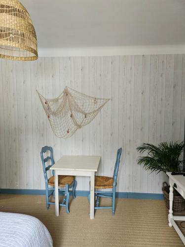 - une chambre avec une table, deux chaises et un hamac sur le mur dans l'établissement Chambres d'hôtes Le Montagné, à Villeneuve-lès-Avignon