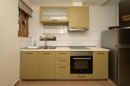 a kitchen with a stove and a refrigerator at Niriides Luxury Villas in Methoni