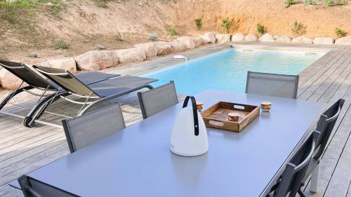 - une table et des chaises à côté de la piscine dans l'établissement Villa Copains, 5 pers, piscine chauffée, 5 mn plage, à Cirendinu