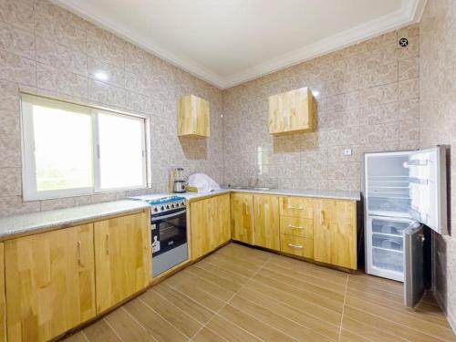 eine Küche mit Holzschränken und einem Kühlschrank in der Unterkunft GM IMMO SARL in Cotonou