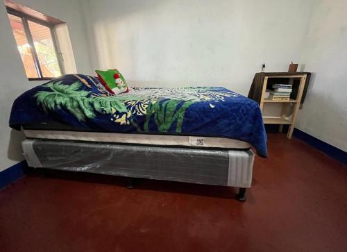 a bedroom with a bed with a blue comforter at ELENA'S HOME STAY in Sololá