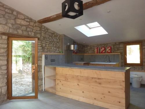 une cuisine avec un comptoir et un mur en pierre dans l'établissement LA BERGERIE DE CORCONNE, à Corconne