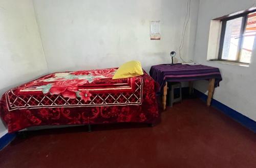 a small room with a bed and a table at ELENA'S HOME STAY in Sololá