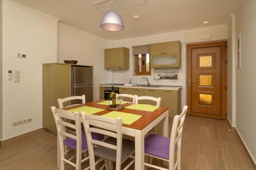 a kitchen with a table and chairs and a kitchen with a refrigerator at Niriides Luxury Villas in Methoni