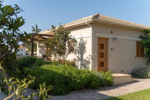 a white house with a gate and a door at Niriides Luxury Villas in Methoni