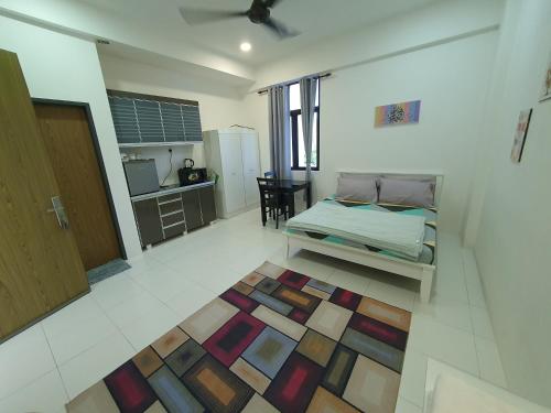 a bedroom with a bed and a kitchen with a table at MyStudio Imperio Home , Alor Setar with sky infinity pool in Alor Setar
