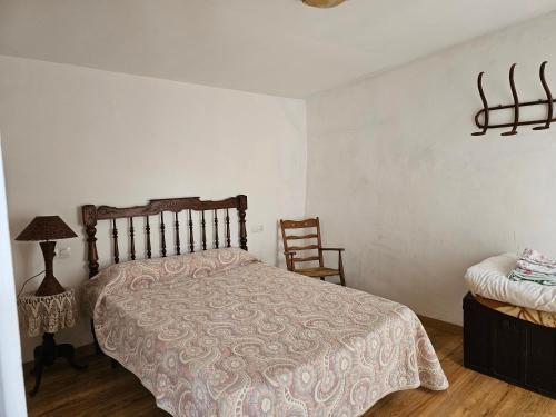 a bedroom with a bed and a chair at CASA RURAL LLAVADOR Vall Guadalest in Benifató