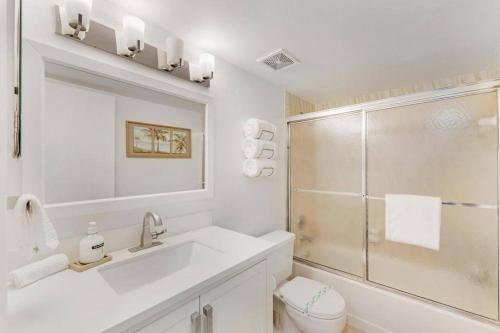 a white bathroom with a sink and a shower at Overlooking Marina/Ocean view & FREE GOLF CART in Key Largo