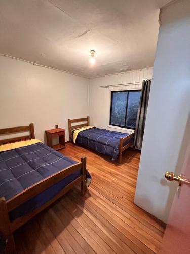 um quarto com 2 camas e uma janela em Casa familiar em Temuco