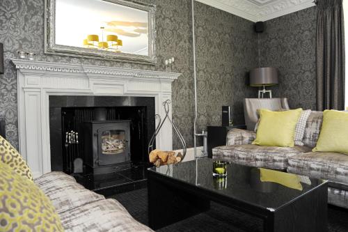 a living room with two couches and a fireplace at The Dowans Hotel of Speyside in Aberlour