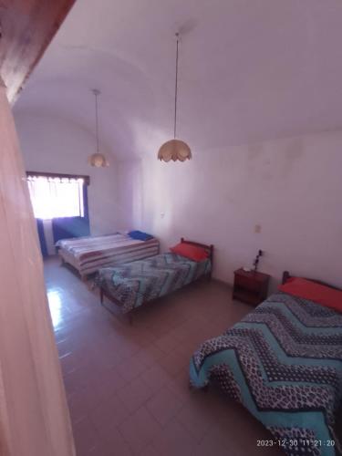 een kamer met 2 bedden en een raam bij emili in Las Grutas