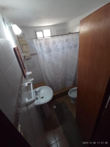 uma casa de banho com um WC, um lavatório e um chuveiro em emili em Las Grutas