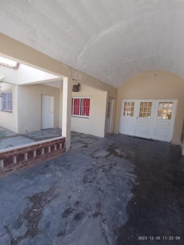 una stanza vuota con due porte bianche e un pavimento in cemento di emili a Las Grutas