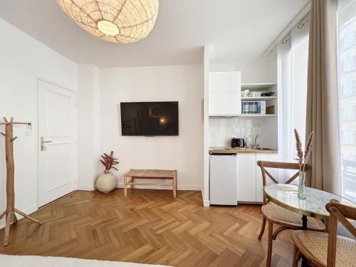 uma sala de estar branca com uma mesa e uma cozinha em - - Maison ŪMA - Marseille - - Wifi, Mer et Centre em Marselha