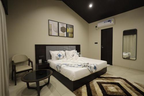 KevadiaにあるVindhyachal Resortのベッドルーム1室(ベッド1台、テーブル、椅子付)