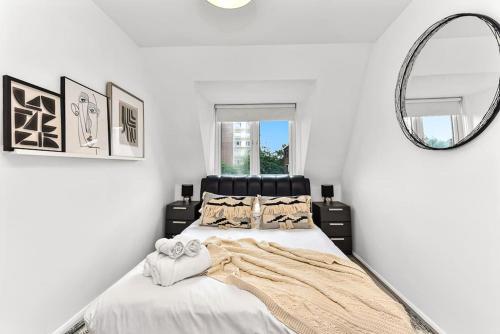 1 Bedroom Apartment- Finsbury Park Station (D) في لندن: غرفة نوم بيضاء مع سرير ومرآة