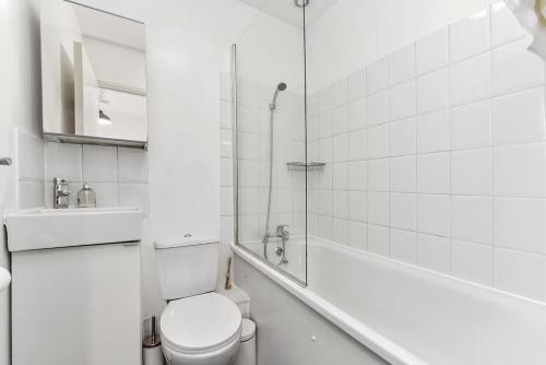 a white bathroom with a toilet and a shower at 1 Bedroom Apartment- Finsbury Park Station (D) in London