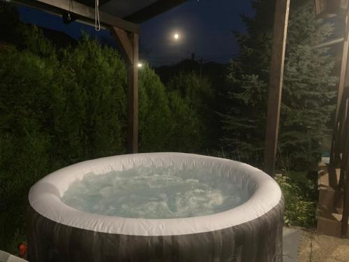 a hot tub on a patio at night at Lux Faház in Parád
