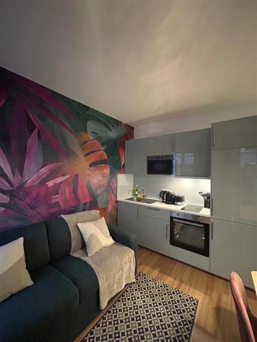 uma sala de estar com um sofá e uma cozinha em Cosy Appartement in Quartier Saint-Georges - 4P em Paris
