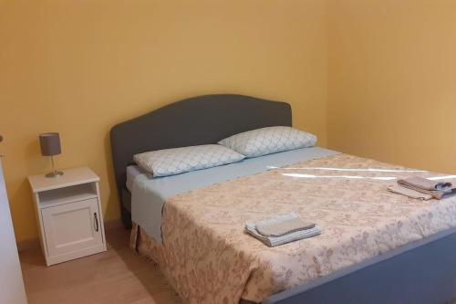 1 dormitorio con 1 cama con cabecera y mesa en Casa Vitiolo - parte sinistra, 