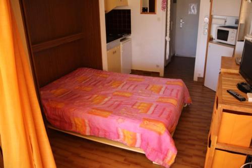 - une chambre avec un lit et une couette rose dans l'établissement Studio 16, Héliopolis FGH au village naturiste, au Cap d'Agde