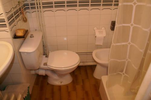 une salle de bain blanche avec des toilettes et un lavabo dans l'établissement Studio 16, Héliopolis FGH au village naturiste, au Cap d'Agde