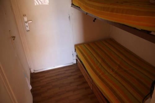 - une petite chambre avec des lits superposés à côté d'une porte dans l'établissement Studio 16, Héliopolis FGH au village naturiste, au Cap d'Agde