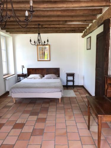 een slaapkamer met een bed en een houten plafond bij Les Gelots in Villemurlin