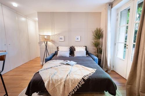 - une chambre avec un grand lit et un canapé bleu dans l'établissement Mulini - 1 chambre à Saint-Germain-Des-Prés, à Paris