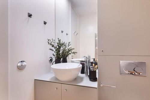 une salle de bain blanche avec un lavabo et un miroir dans l'établissement Mulini - 1 chambre à Saint-Germain-Des-Prés, à Paris
