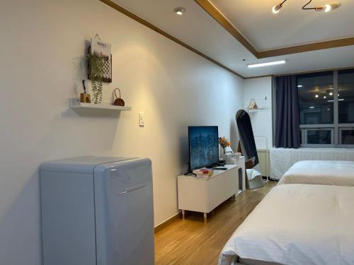a bedroom with two beds and a television in it at Serein_HongDae in Seoul