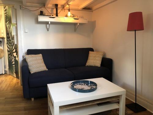 sala de estar con sofá y mesa en Chambre cosy dans petit loft, en París