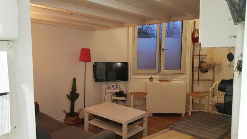 sala de estar con sofá y TV en Chambre cosy dans petit loft en París