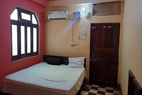 a small room with a bed and a window at OYO Prabha Guest House in Robertsganj
