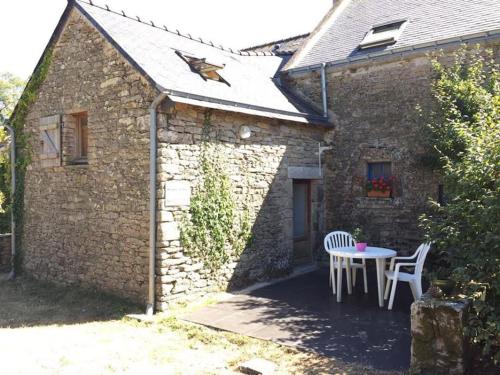 a stone house with a table and chairs outside at Meublé sur l'ILE DE TASCON à 300 m de la plage in Saint-Armel