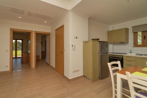 a kitchen with a table and a refrigerator at Niriides Luxury Villas in Methoni