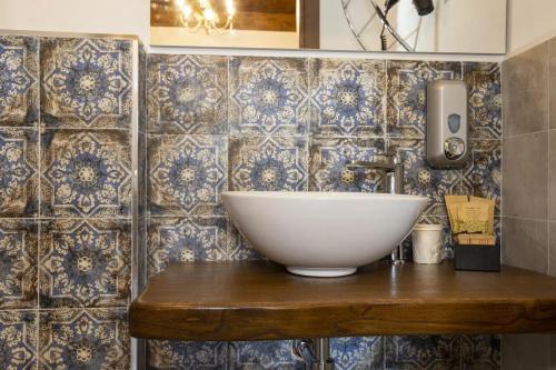 a bathroom with a bowl sink on a wooden table at Arcaloro Resort Rooms Ghiro in SantʼAngelo di Brolo