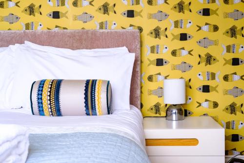 a bedroom with a bed with a yellow wall at The Bell Inn in Walberswick